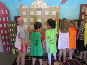 a group of super hero kids pretend to fly over buildings