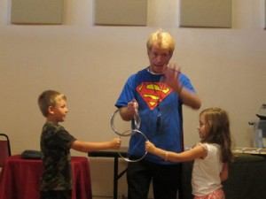 magician beguiles 2 kids with rings trick